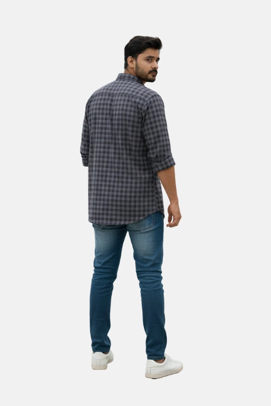 Man wearing a checkered shirt and jeans on a plain background - Men’s Casual Slim Fit Plaid Shirt – Dark Grey & Black Checked Cotton Button-Up - Royal Outfits - Printed Shirts - Men’s Casual Slim Fit Plaid Shirt – Dark Grey & Black Checked Cotton Button-Up - Royal Outfits