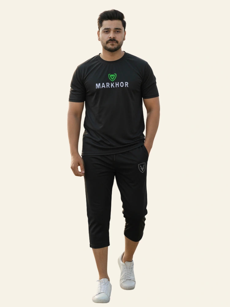 Man wearing a black 'Markhor' branded outfit on a beige background