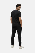 Man wearing a black t-shirt and black pants on a beige background - Black 'Markhour' Tracksuit - Royal Outfits - Track Suits - Black 'Markhour' Tracksuit - Royal Outfits