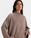 Woman wearing a brown turtleneck sweater on a white background