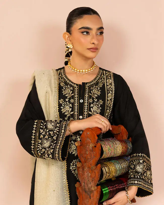 Girl wearing black shalwar kameez suit having bangle collections with her